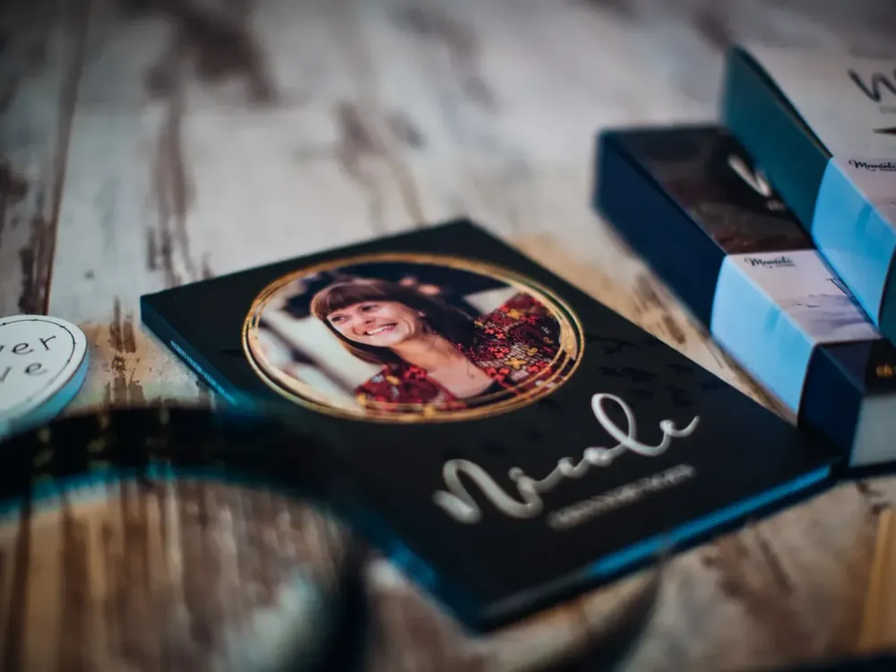 A finished memorial book with the name "Nicole" and a portrait photo on the matte hardcover