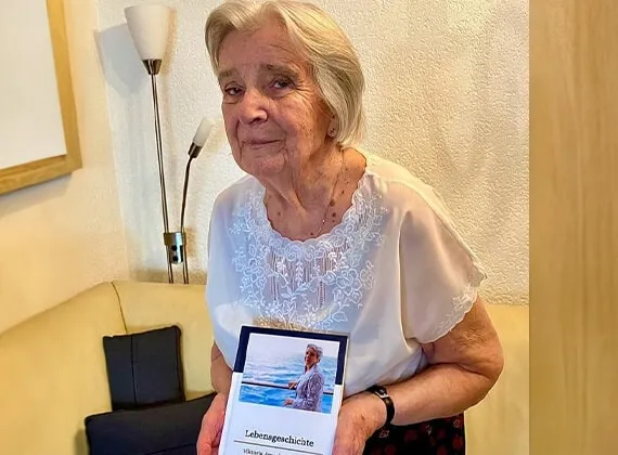 Viktoria hält ein eigenes Meminto Buch in den Händen