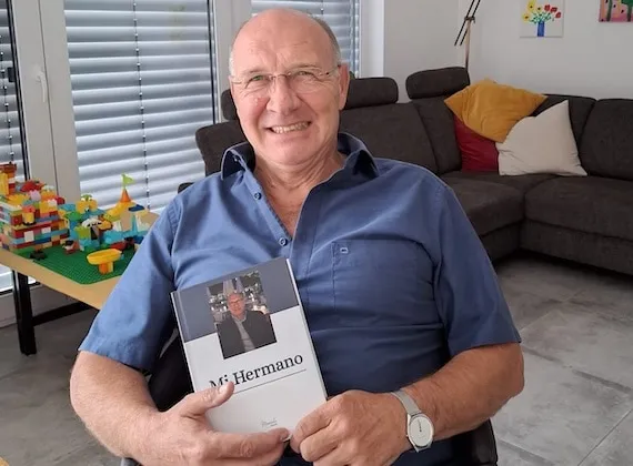 Werner hält ein eigenes Meminto Buch in den Händen