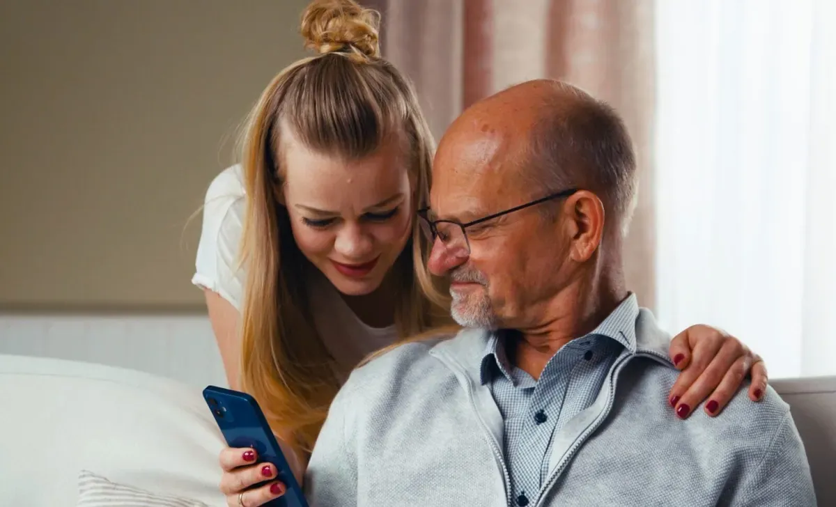 Vater und Tochter schauen gemeinsam auf ein Smartphone