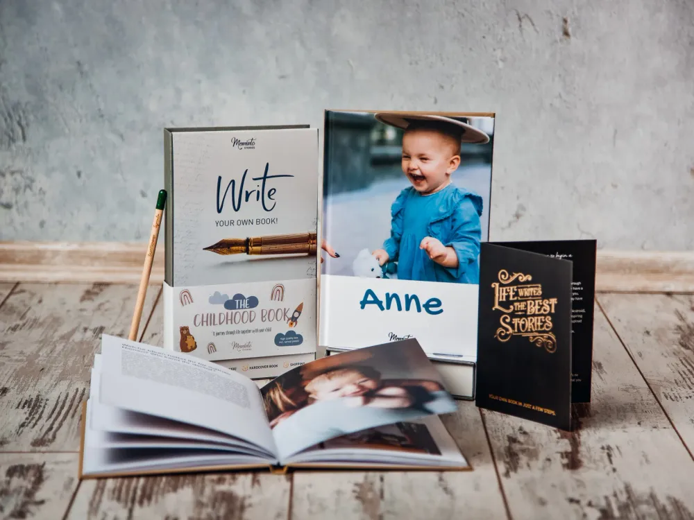 A Meminto book with its gift box, card and pencil on a wooden floor