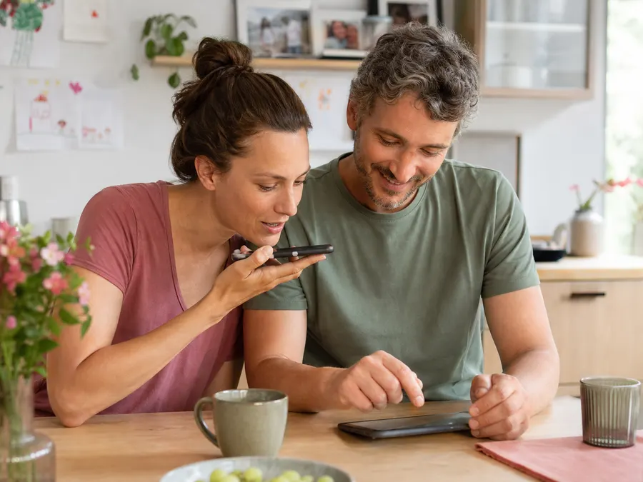 Parents answering questions together for a Childhood Memory Book on a smartphone