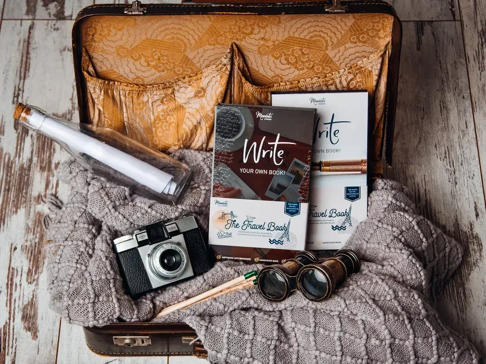 Two Meminto Travel Books in the starter gift box with its English sleeve, packed in a vintage suitcase