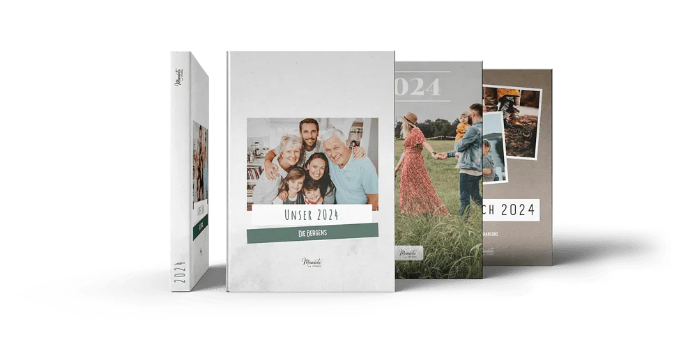 Drei fertige Meminto Familien-Jahrbücher mit Familienfotos auf dem Cover, Jahrgang 2024