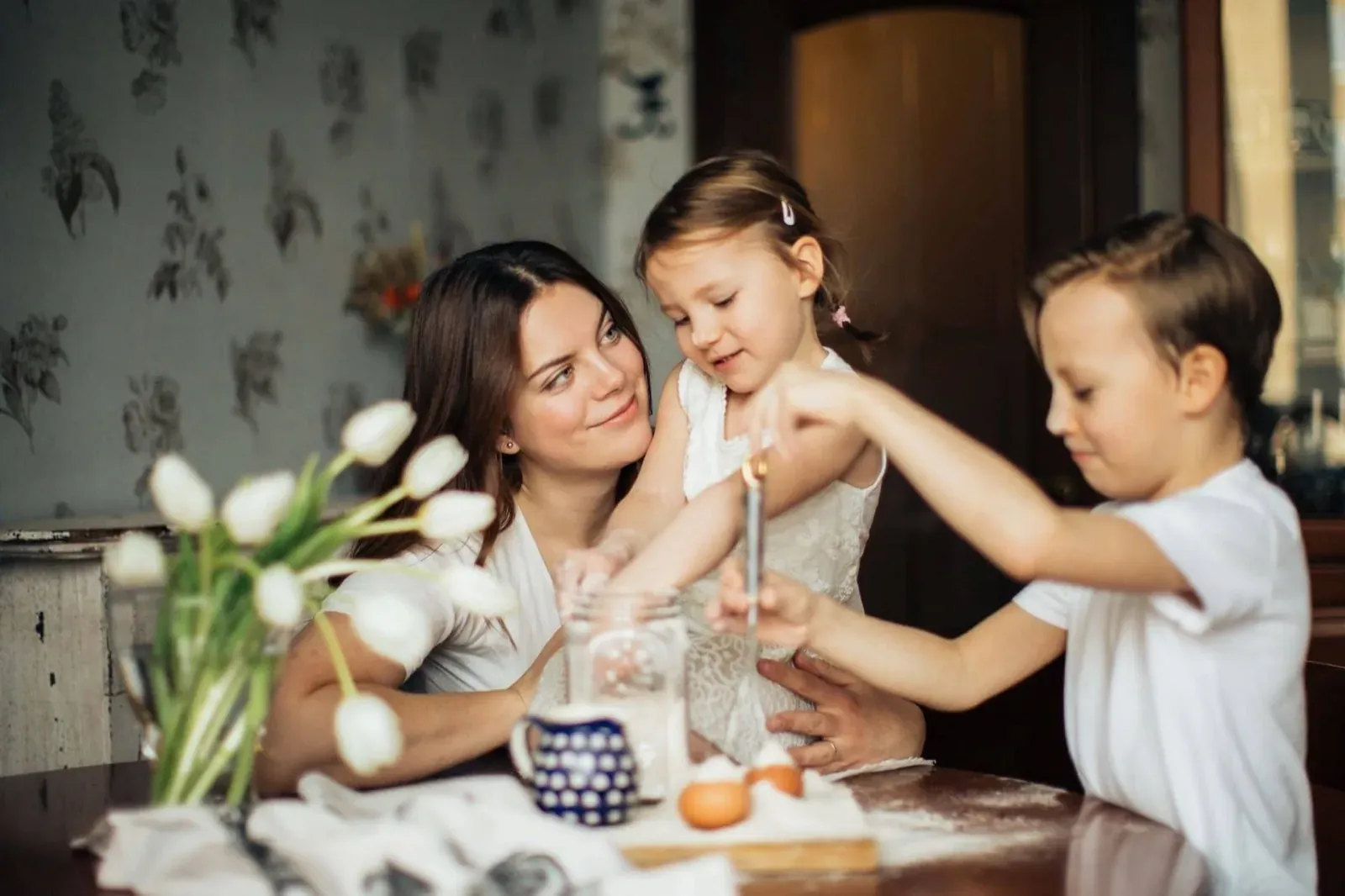 A mother and two children sit together at a table, creating a family memory.