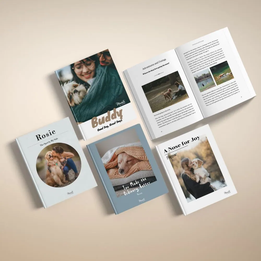 Several dog memory books laid out flat, one open to a spread with photos and text