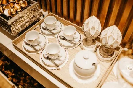 Tray set with white porcelain cups, saucers, spoons and a teapot