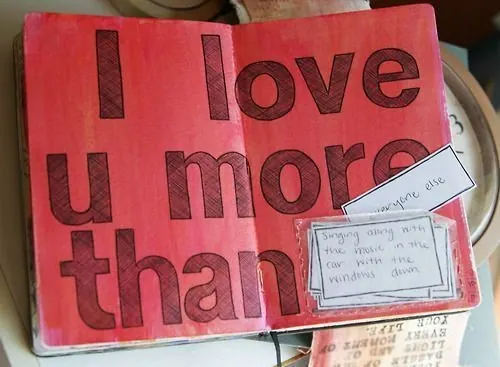 Open journal with hand-painted red pages reading I love u more than, plus tucked-in notes