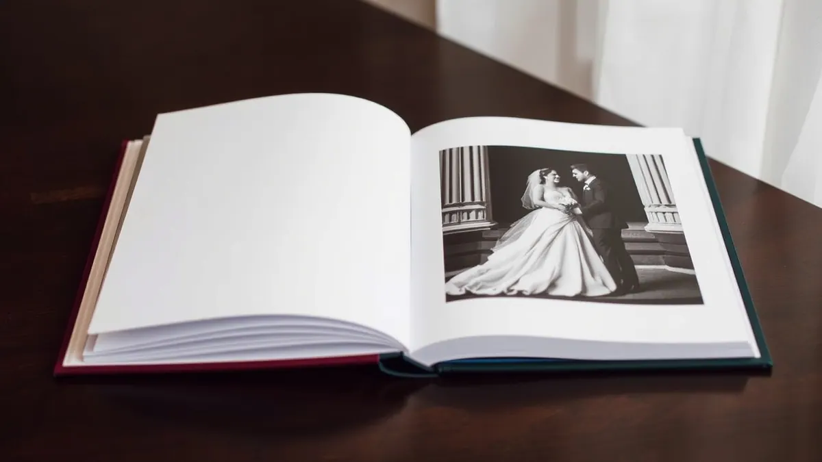An open album shows a black and white wedding photo on one page