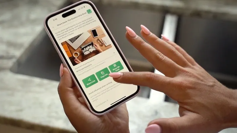 Hände halten ein Smartphone und tippen in der Meminto App auf den Button zum Teilen des Buches