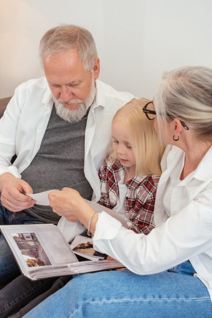 A couple looking on a personal history book with their grandchild
